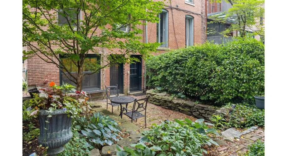 Private patio with brick building, greenery and seating in Boston getaway rental