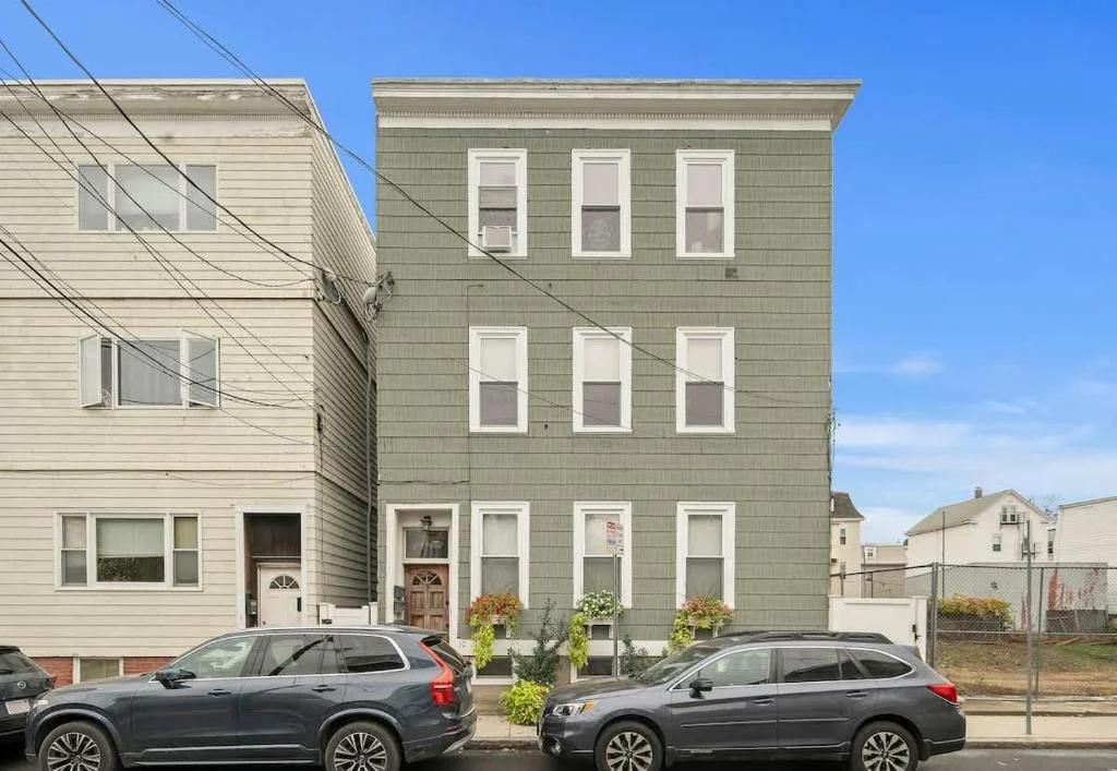 Sage green three-story townhouse with white-trimmed windows and welcoming entrance, a romantic getaway rental in Cambridge,