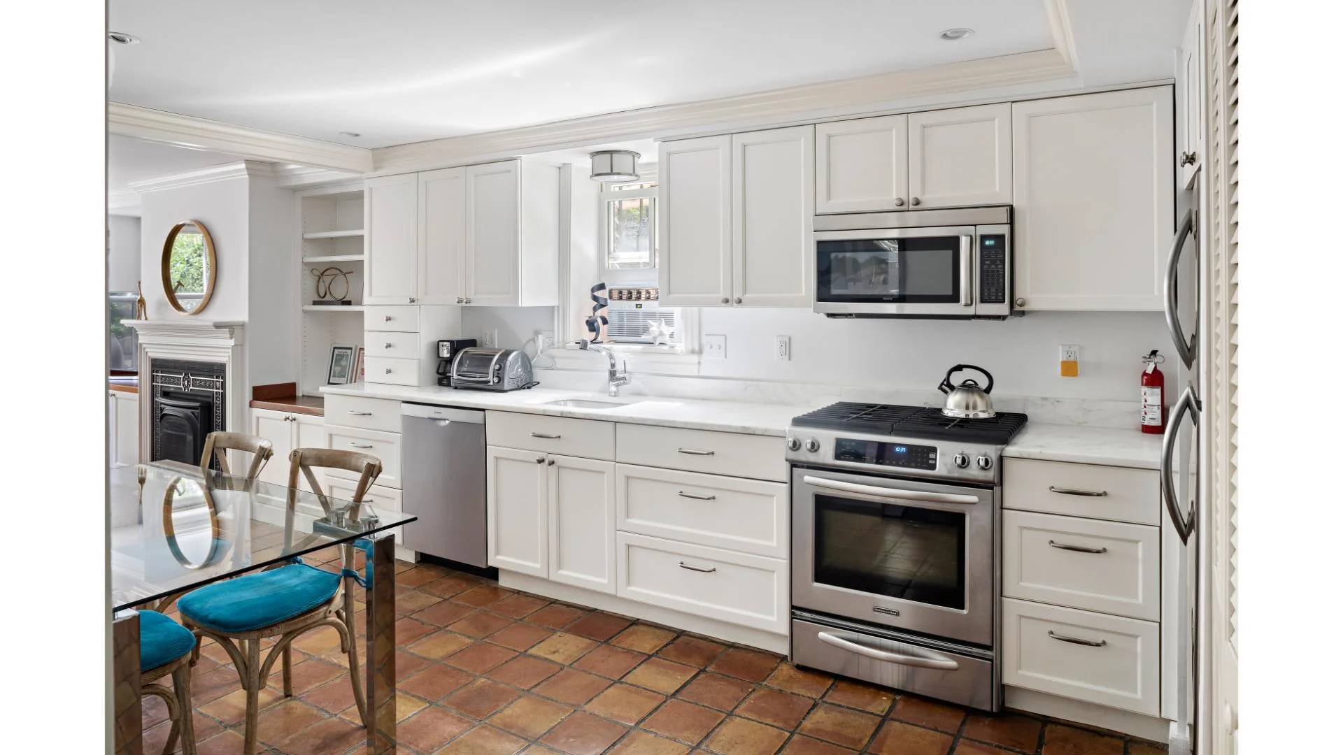 Modern kitchen with white cabinetry and stainless steel appliances in a Boston short-term rental