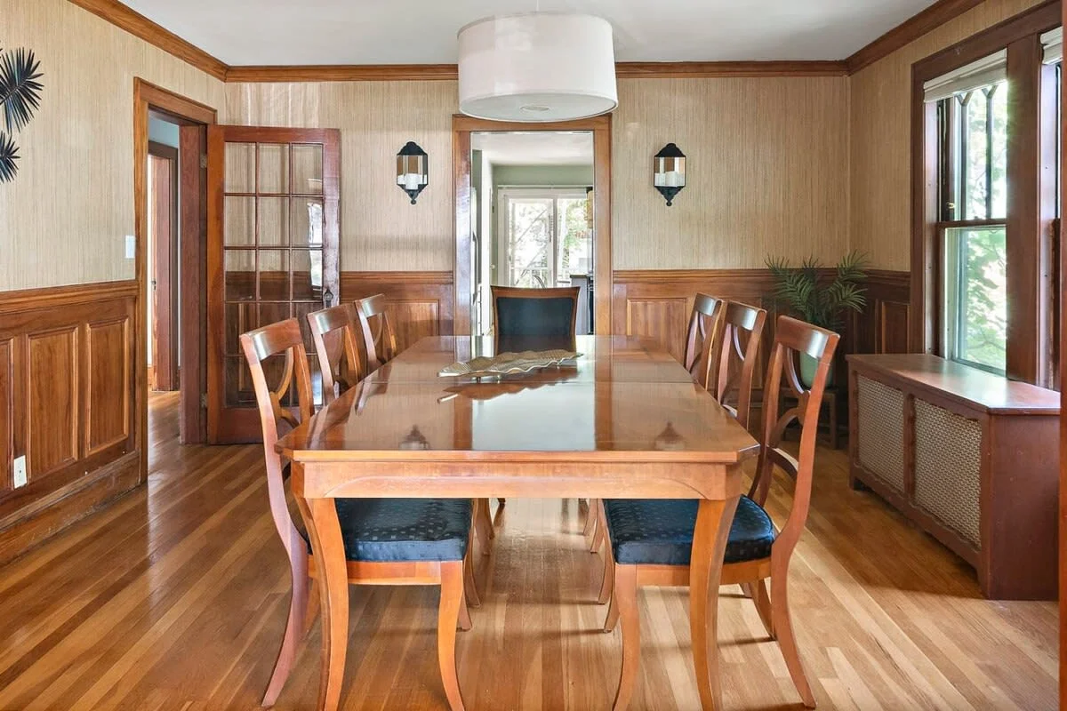 Formal dining room with wooden table, hardwood floors, and wainscoting in Boston vacation rental
