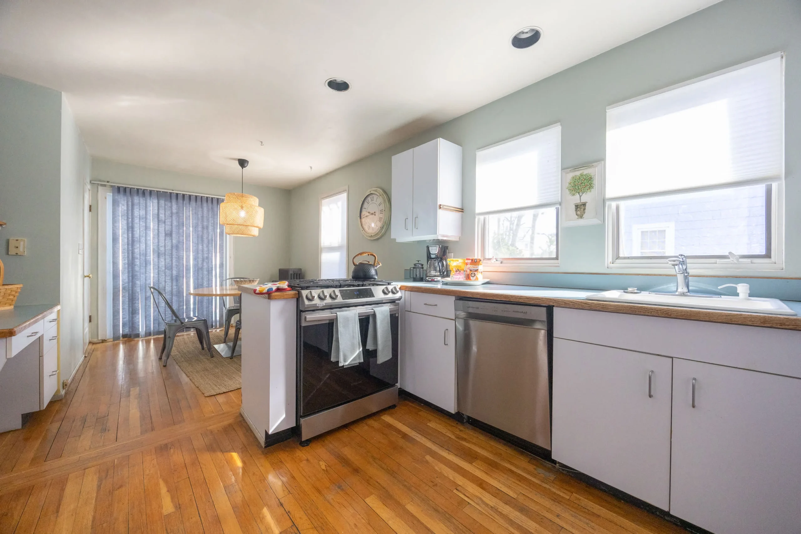 Bright modern kitchen with white cabinets, stainless steel appliances, and hardwood floors in a Boston, MA rental by South